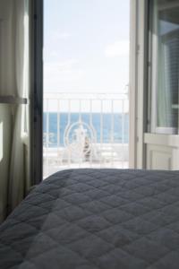 um quarto com uma cama e vista para o oceano em Casa San Vito em Monopoli