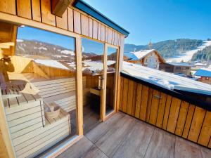 un balcón de una casa con puertas correderas de cristal en AlpinLodge Flachau, en Flachau