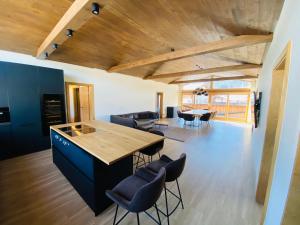 cocina y sala de estar con techo de madera en AlpinLodge Flachau, en Flachau