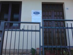 a building with two doors and a clock on it at La Vallata B&B in Sardegna in Ghilarza