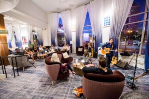 a group of people sitting in a living room with instruments at Saint Kate - The Arts Hotel in Milwaukee