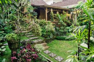 un giardino con sentiero di fronte a una casa di Desak Putu Putra Hidden ad Ubud