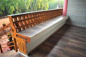 a wooden bench sitting on a porch with a window at Viraz Valley in Gokarna