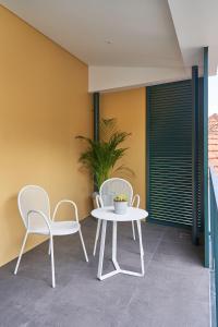 twee witte stoelen en een tafel op een patio bij Good Memories Lodge in Funchal