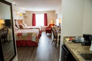 a hotel room with a bed and a desk at The Village Inn of Lakefield in Lakefield