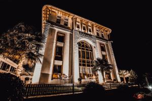 um grande edifício com muitas janelas à noite em Sharm Hotel Luxury em Gjirokastër