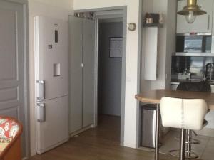 a kitchen with a refrigerator and a table and a counter at Une terrasse sur la mer in Crozon