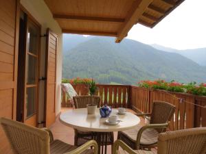 una mesa y sillas en un balcón con vistas en Agriturismo Kabishof, en Funes