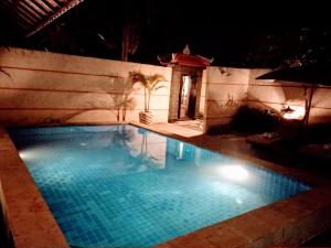 ein Schwimmbad in der Nacht mit eingeschaltetem Licht in der Unterkunft Kartika Dahayu Private Pool Villas in Sukawati