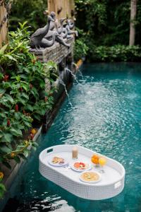 un tavolo in acqua con cibo e bevande di Desak Putu Putra Hidden ad Ubud