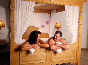 a man and a woman sitting on a bed at Hotel Sonnekalb in Naumburg