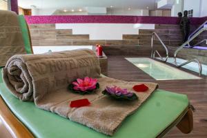 a towel and flowers on a table next to a pool at Grand Hotel Sestriere in Sestriere