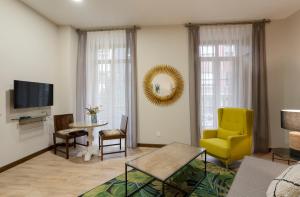 un salon avec une chaise jaune et une table dans l'établissement DE LA GUARDIA SUITE 1, à Oviedo