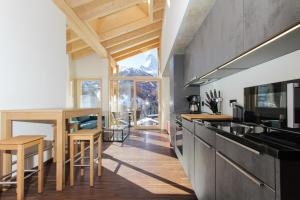 een keuken met een aanrecht en een eetkamer met een tafel bij House Mojo in Zermatt