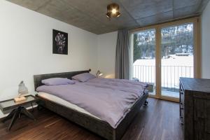 een slaapkamer met een bed en een groot raam bij House Mojo in Zermatt