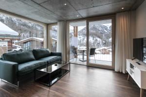 een woonkamer met een bank en een televisie bij House Mojo in Zermatt