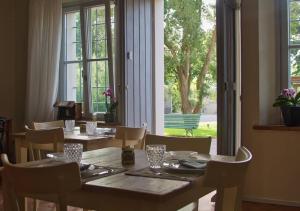 un comedor con mesas y sillas y una gran ventana en Agriturismo Poderedodici, en Orbetello