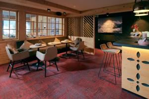 un restaurant avec un bar doté de chaises et d'une table dans l'établissement Hotel Central Wolter - Grindelwald, à Grindelwald