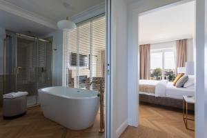 a bathroom with a tub and a bedroom with a bed at Porto Romano - The Marina Resort in Fiumicino