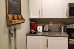 een keuken met witte kasten en een aanrecht bij 1-Bedroom Apartment Bellisimo AG by Amazing Property Rentals in Gatineau