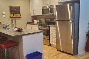 een keuken met een grote roestvrijstalen koelkast bij 1-Bedroom Apartment Bellisimo AG by Amazing Property Rentals in Gatineau