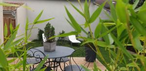 een patio met een tafel, stoelen en planten bij clos des mûriers in Beaune