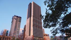 Oaks Melbourne on William Suites في ملبورن: مبنى طويل في مدينة ذات مبنيين طويلين