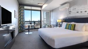 سرير أو أسرّة في غرفة في Oaks Melbourne on William Suites