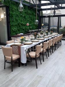 een lange tafel met stoelen en borden erop bij Hotel Litovel in Komárno