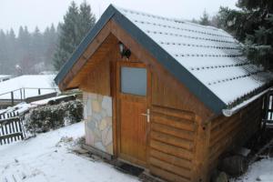 a smallshed with a wooden door in the snow at Ferienhaus Wittmann in Kurort Oberwiesenthal