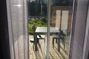 a table and chair on a patio outside a window at Appartement Alouette France in Pessac