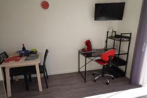 a room with a table and a red chair and a desk at Appartement Alouette France in Pessac