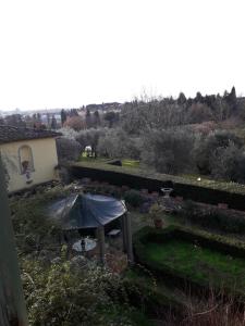 een tuin met een tafel en een parasol bij Villa Le Pergole- Firenze in Florence