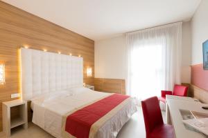 una camera con un letto e due sedie rosse di Hotel Victoria a Vicenza