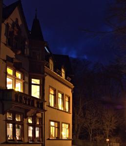 un bâtiment avec ses lumières allumées la nuit dans l'établissement Parkschlösschen in Greiz, à Greiz