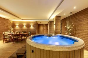 une baignoire jacuzzi dans une chambre avec une table dans l'établissement Rezidence Moser Apartments, à Karlovy Vary