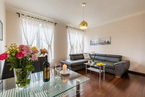 - un salon avec un canapé et une table fleurie dans l'établissement Rezidence Moser Apartments, à Karlovy Vary