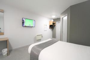 a bedroom with a bed and a tv on the wall at Citilodge Wakefield Hotel by Roomsbooked in Wakefield