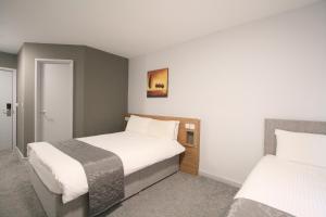 a hotel room with two beds in a room at Citilodge Wakefield Hotel by Roomsbooked in Wakefield