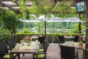 um restaurante com mesas, cadeiras e guarda-sóis em seehaus forelle haeckenhaus em Ramsen