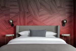 a bedroom with a bed with a red wall at  Liz by Black Swan - DC Executive Flat in Washington