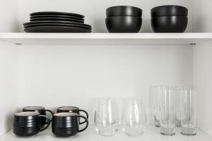 a shelf with cups and glasses on it at  Liz by Black Swan - DC Executive Flat in Washington