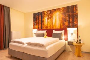 a bedroom with a bed with a painting on the wall at Mythenresort Heimdall in Thale