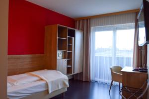 - une chambre avec un lit, un bureau et une fenêtre dans l'établissement Hotel Römerhof, à Tulln