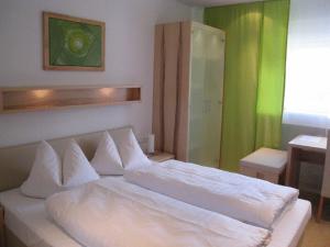 een wit bed in een kamer met een groene muur bij Hotel Barbarina in Tübingen