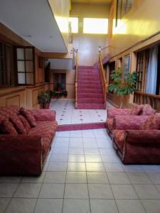 une grande chambre avec canapés et escaliers dans un bâtiment dans l'établissement Hotel San Juan, à Coquimbo