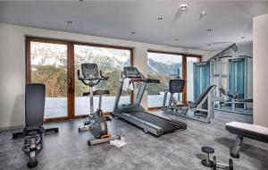 - une salle de sport avec plusieurs appareils d'exercice devant une fenêtre dans l'établissement Der Burgfellnerhof - Adults Only, à Schladming