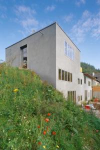 um edifício no topo de uma colina com um campo de flores em seehaus forelle haeckenhaus em Ramsen