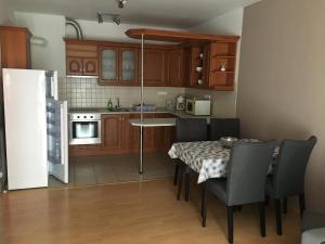 een keuken met een tafel en stoelen en een koelkast bij Peppy Apartment & Pool in Balatonfüred