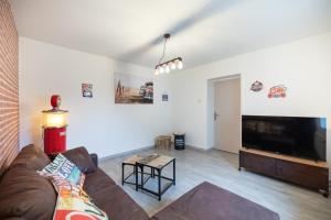 a living room with a couch and a large flat screen tv at Résidence 3 etoiles Les thèmes Proche Lux, Metz, Cattenom in Hayange